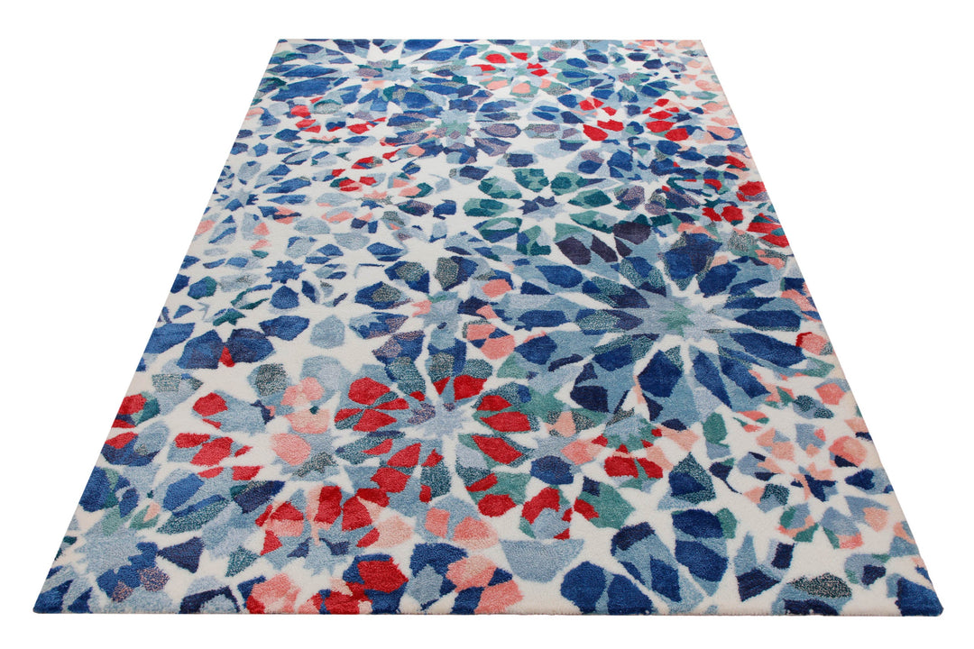Mosaikblüte in Hellblau - Handtuft Wolle 160 x 230 cm – Teppich im Raum platziert