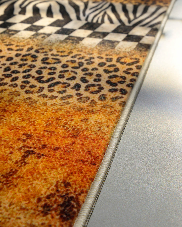 Nahaufnahme der sauber eingefassten Kante des Badteppichs Jungle Stripes mit Animal-Print-Design.