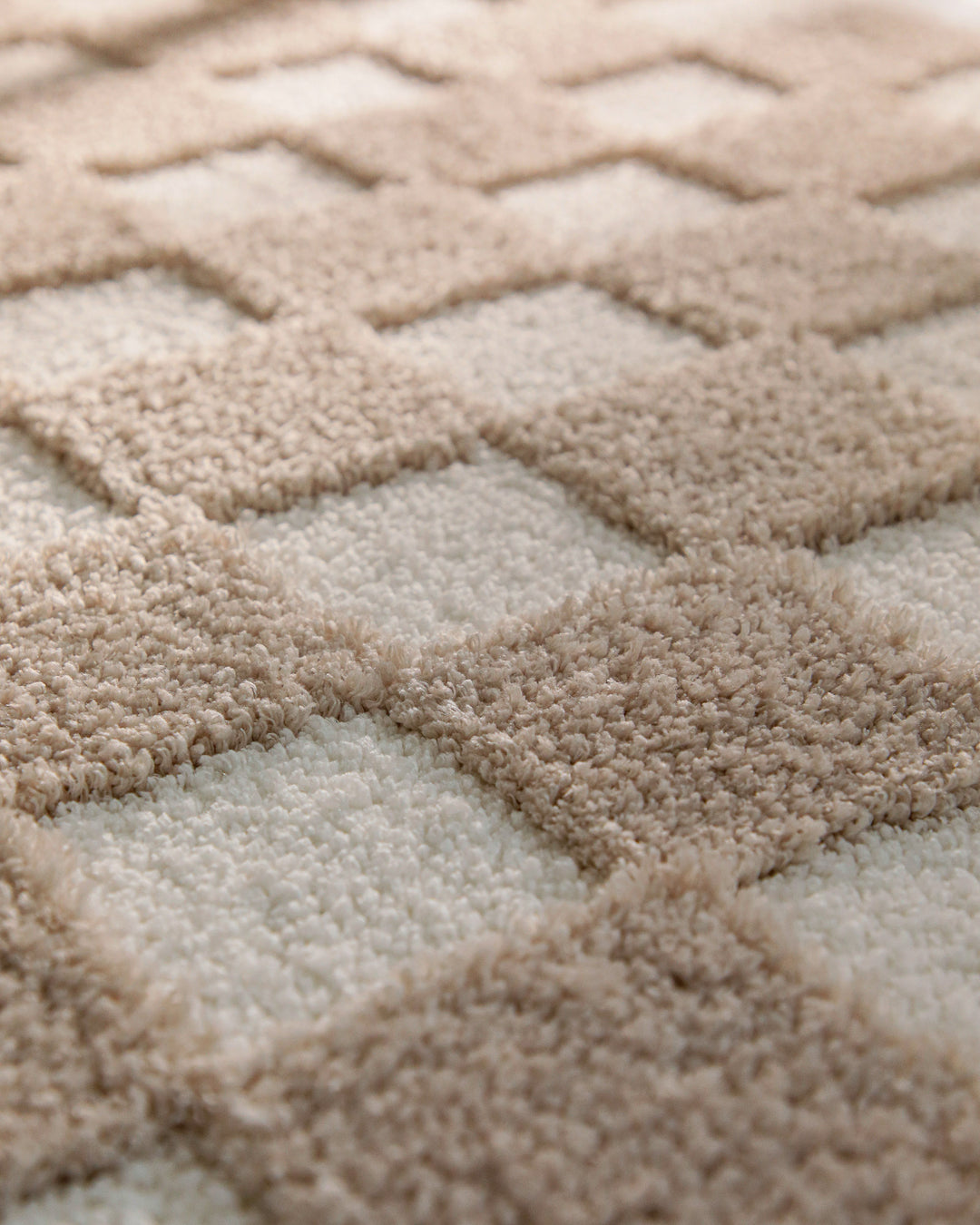 Badteppich Bobbi Beige Nahaufnahme der Florstruktur mit kontrastierendem Karomuster