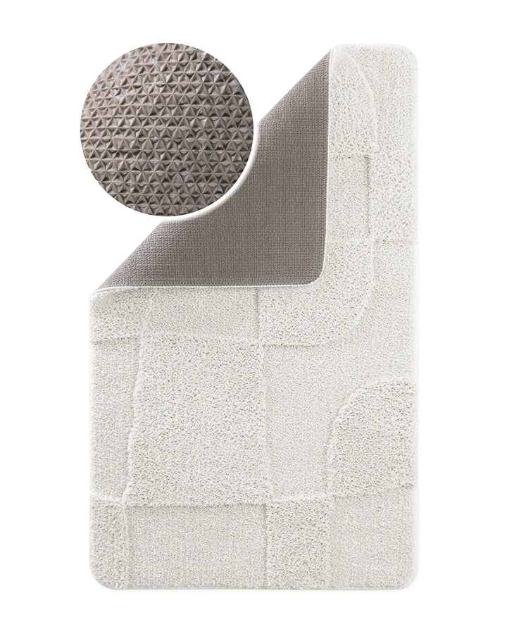 Badteppich Davie Weiß Ecke hochgeklappt, runde Probe zeigt graue Rückseite mit rutschhemmender Beschichtung