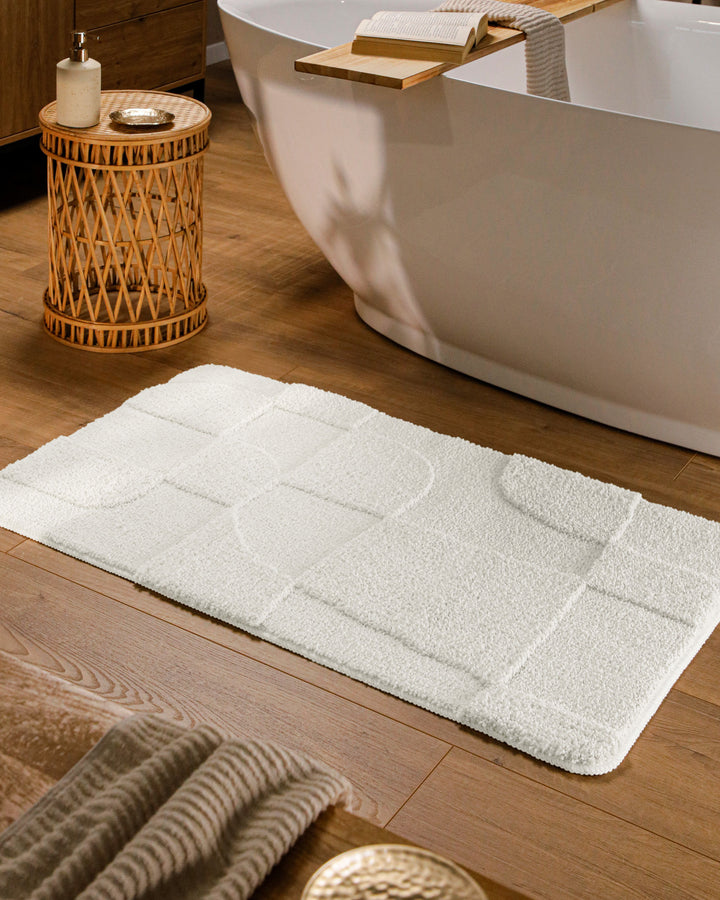 Badteppich Davie Weiß rechteckig im Badezimmer vor Badewanne auf Holzboden liegend, Strukturmuster im Flor sichtbar