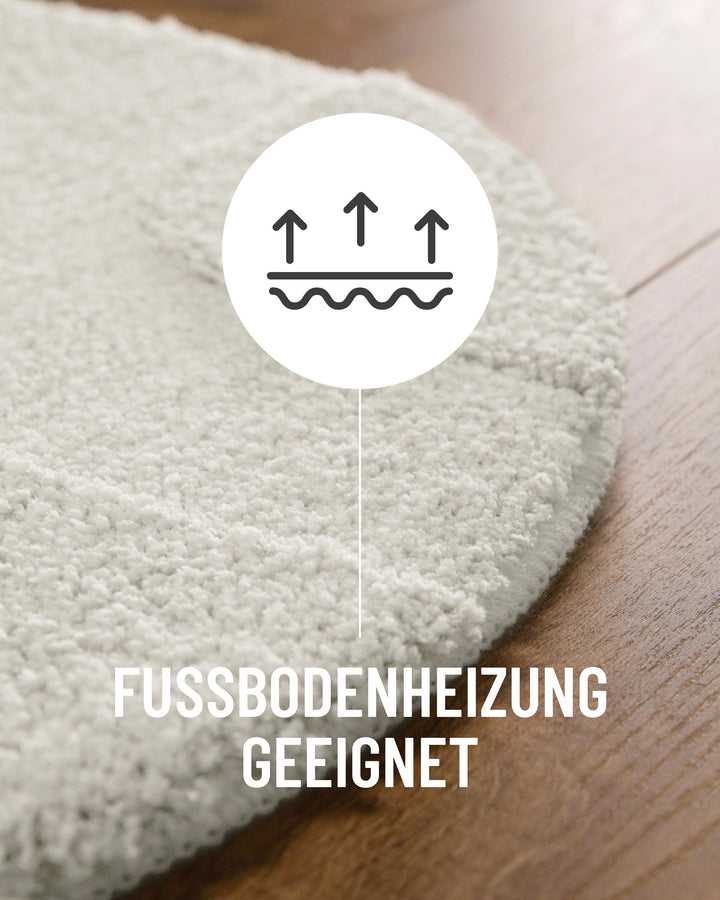 Badteppich Davie Weiß Detail der Teppichkante auf Holzboden, Symbol weist auf Eignung für Fußbodenheizung hin