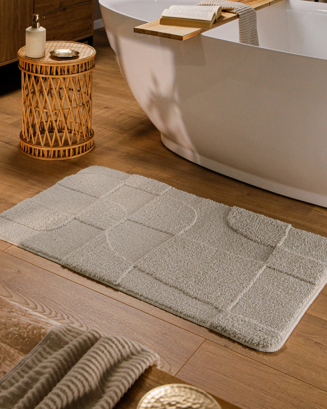 Badteppich Davie Grau rechteckig im Badezimmer vor Badewanne auf Holzboden liegend, Strukturmuster im Flor sichtbar