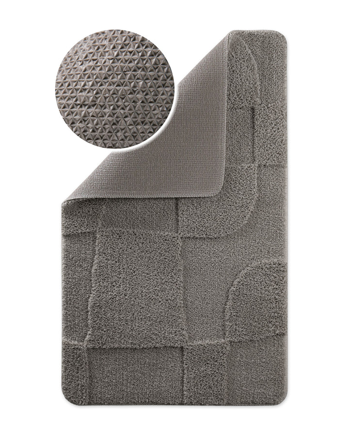 Badteppich Davie Basalt Grau Ecke hochgeklappt, runde Probe zeigt Basalt Graue Rückseite mit rutschhemmender Beschichtung