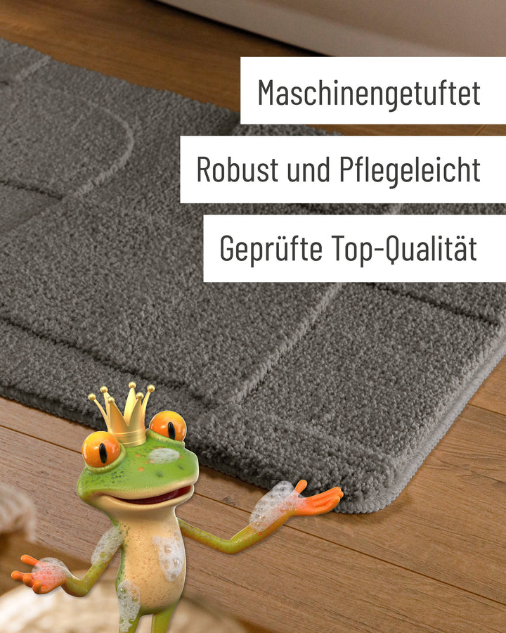 Badteppich Davie Basalt Grau Detail der Teppichkante auf Holzfußboden, eingeblendete Hinweise zu Verarbeitung und Pflege