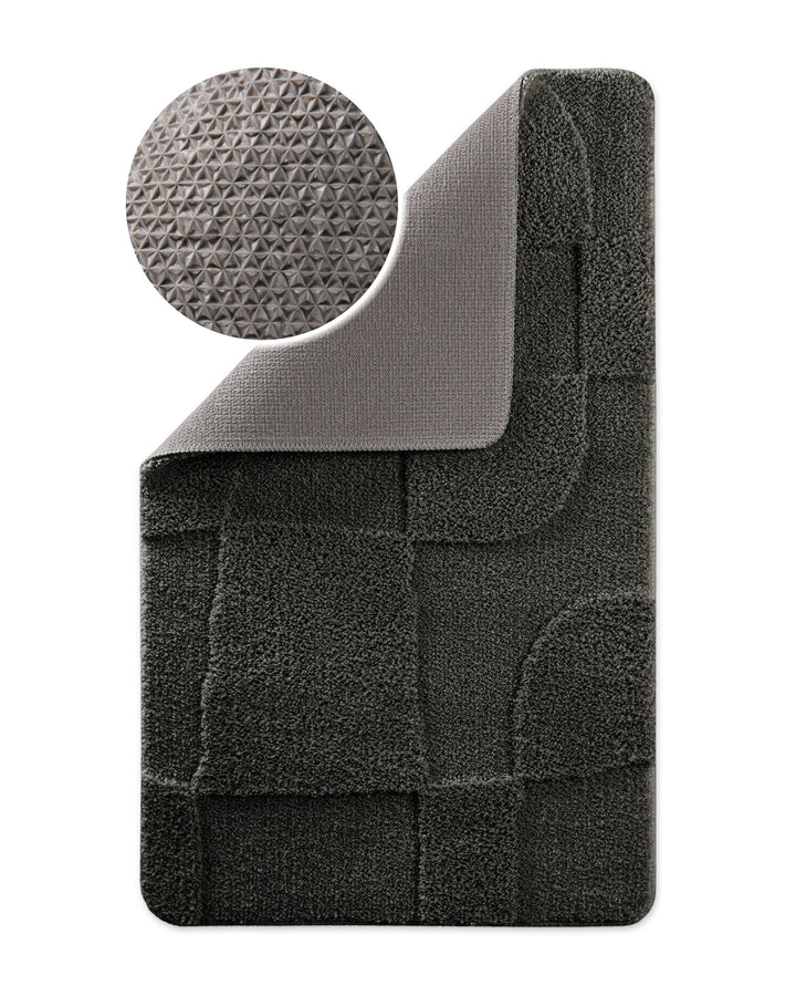 Badteppich Davie Anthrazit Grau Ecke hochgeklappt, runde Probe zeigt Anthrazit Graue Rückseite mit rutschhemmender Beschichtung