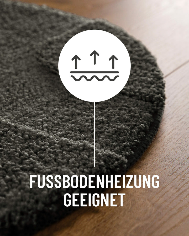 Badteppich Davie Anthrazit Grau Detail der Teppichkante auf Holzboden, Symbol weist auf Eignung für Fußbodenheizung hin