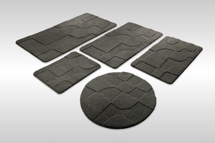 Badteppich Davie Anthrazit Grau Set aus rechteckigen und runden Badmatten, mehrere Größen auf hellem Hintergrund angeordnet