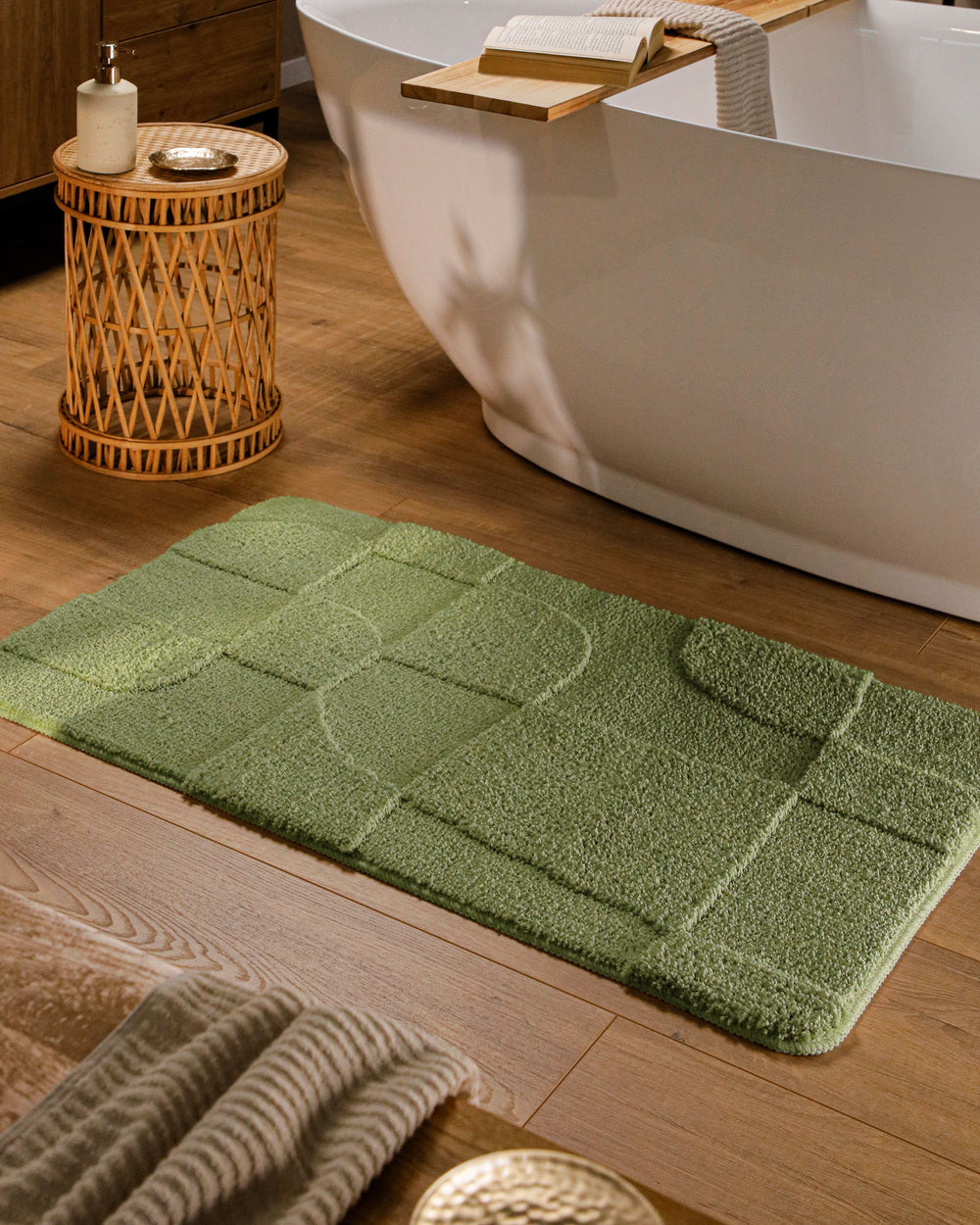 Badteppich Davie Reseda Grün rechteckig im Badezimmer vor Badewanne auf Holzboden liegend, Strukturmuster im Flor sichtbar