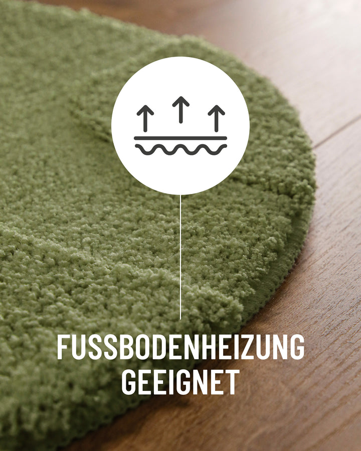 Badteppich Davie Reseda Grün Detail der Teppichkante auf Holzboden, Symbol weist auf Eignung für Fußbodenheizung hin