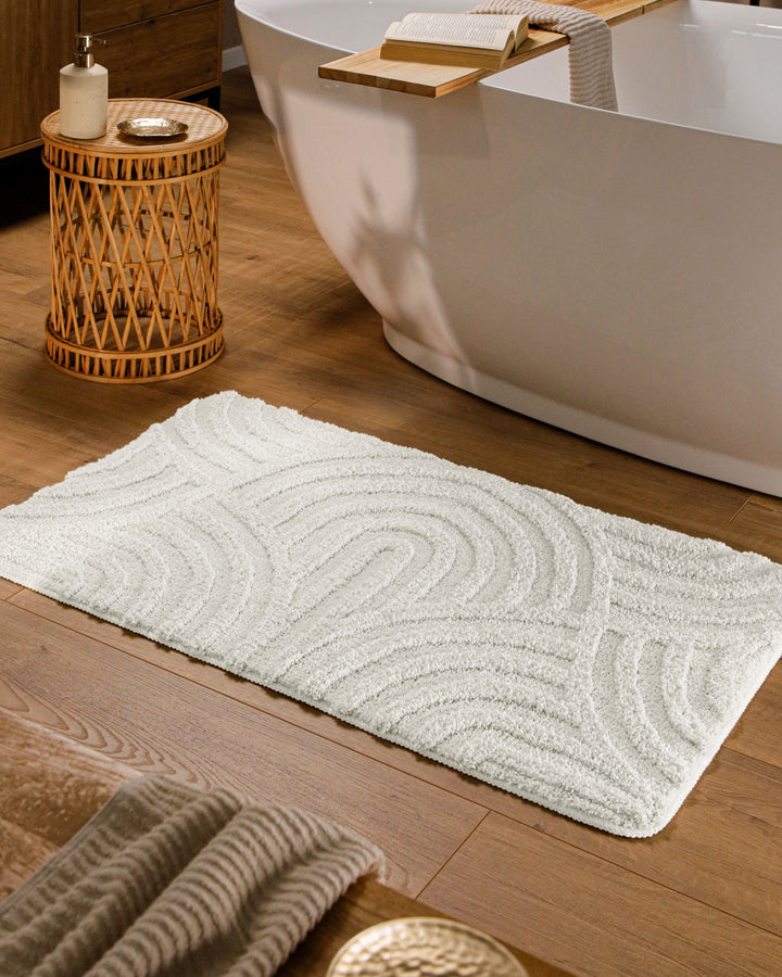 Badteppich Fiete Weiß rechteckig im Badezimmer vor Badewanne auf Holzboden liegend, Strukturmuster im Flor sichtbar
