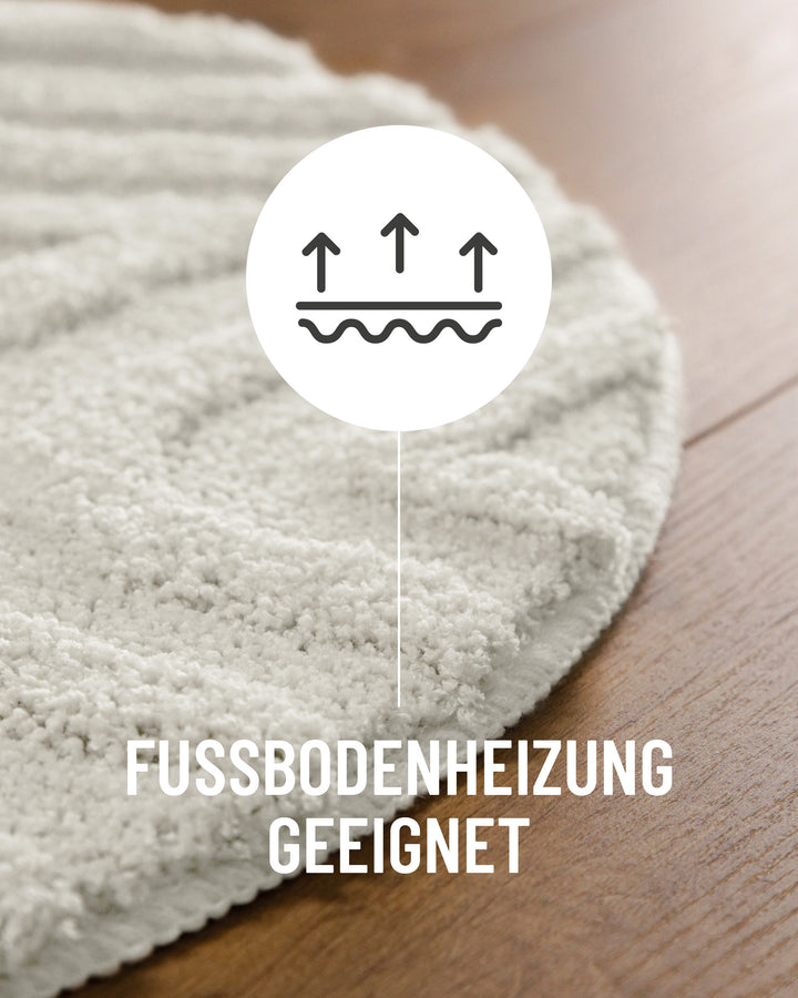 Badteppich Fiete Weiß Detail der Teppichkante auf Holzboden, Symbol weist auf Eignung für Fußbodenheizung hin