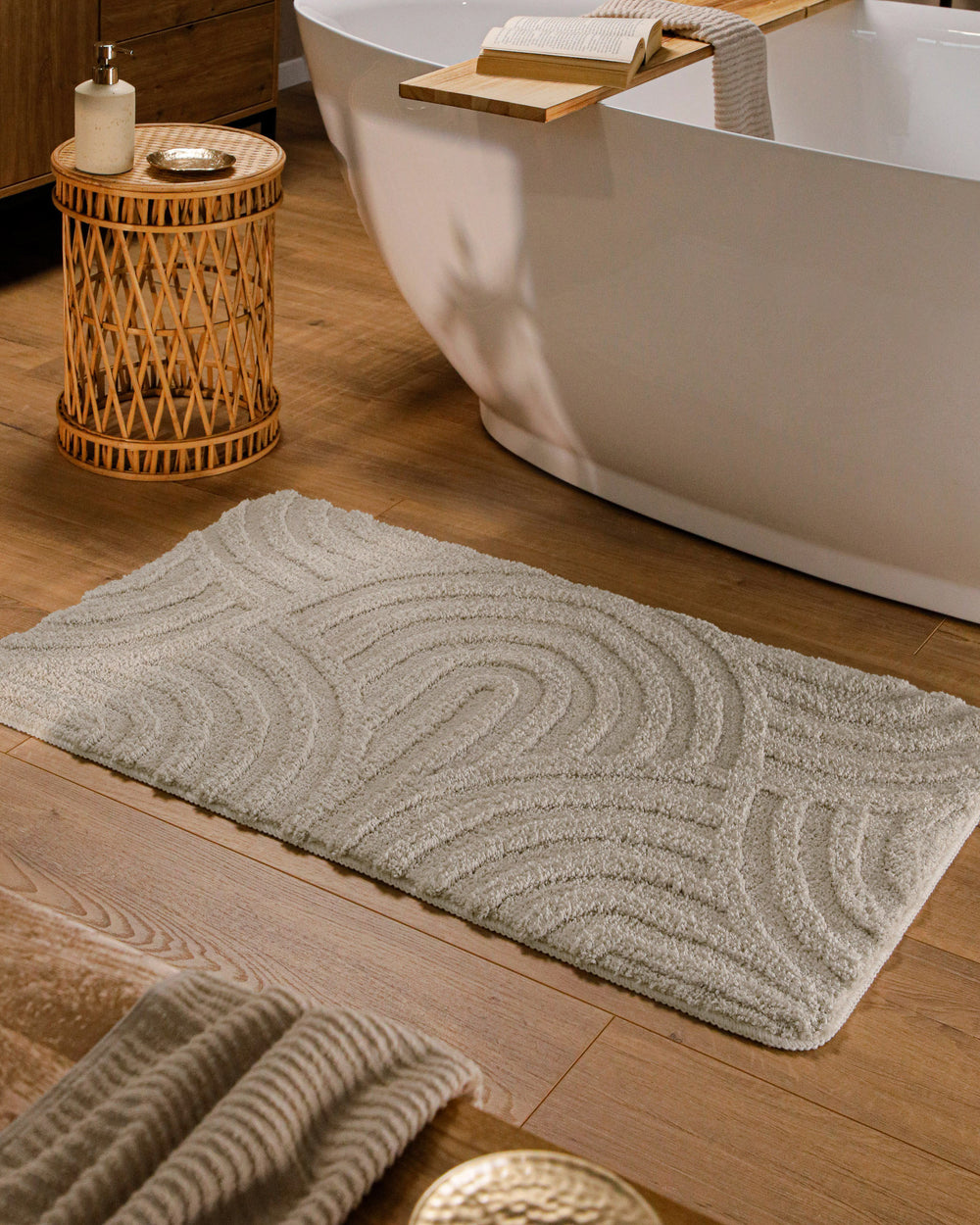 Badteppich Fiete Grau rechteckig im Badezimmer vor Badewanne auf Holzboden liegend, Strukturmuster im Flor sichtbar