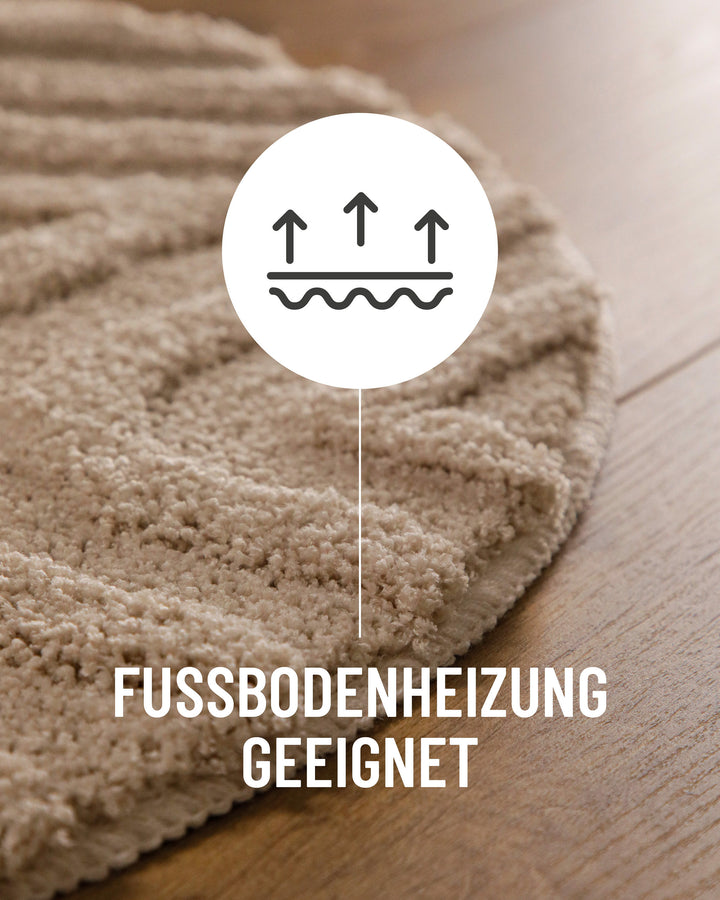Badteppich Fiete Sand Beige rund im Badezimmer auf Holzboden neben Badewanne, Florstruktur und Linienrelief erkennbar