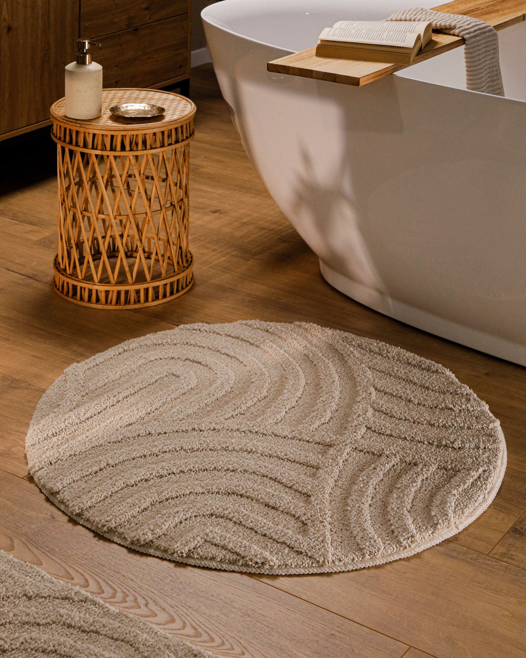 Badteppich Fiete Sand Beige Detailaufnahme mit umgeschlagener Ecke, Hinweisgrafik zur rutschhemmenden Rückseite und Waschbarkeit