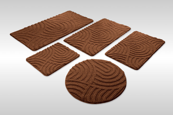 Badteppich Fiete Braun Set aus rechteckigen und runden Badmatten, mehrere Größen auf hellem Hintergrund angeordnet