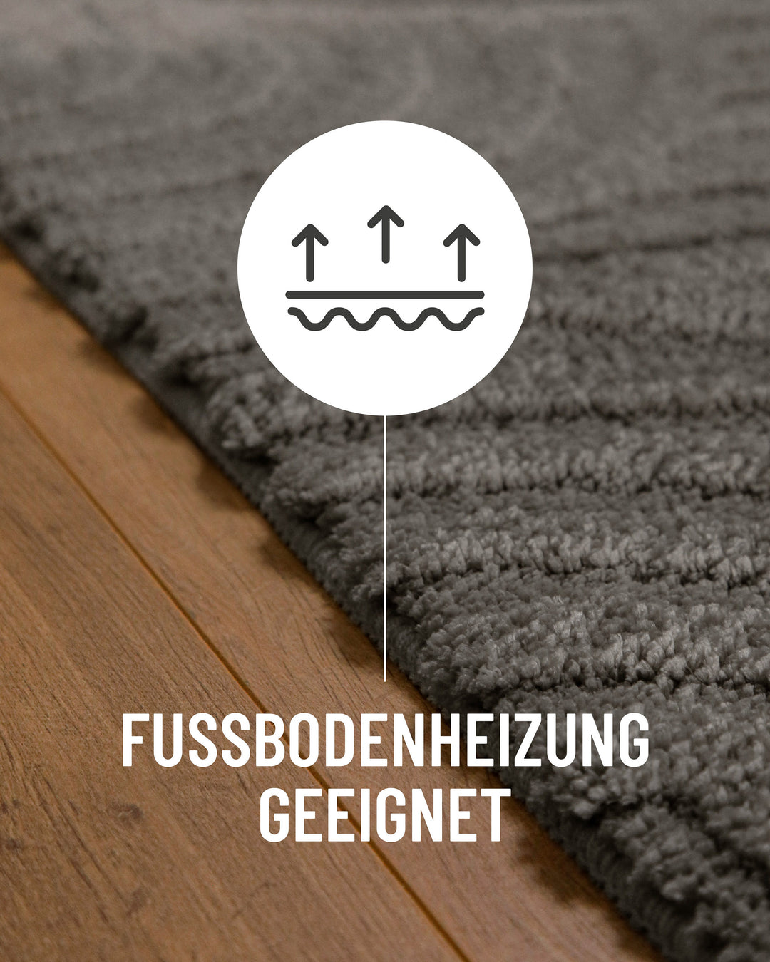 Badteppich Fiete Basalt Grau Detail auf Holzfußboden mit Symbol für Fußbodenheizung, Nahaufnahme von Flor und Teppichkante