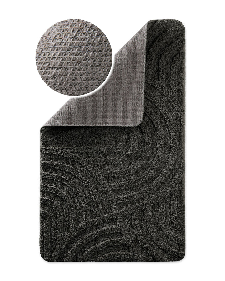 Badteppich Fiete Anthrazit Grau Ecke hochgeklappt, runde Probe zeigt Anthrazit Graue Rückseite mit rutschhemmender Beschichtung
