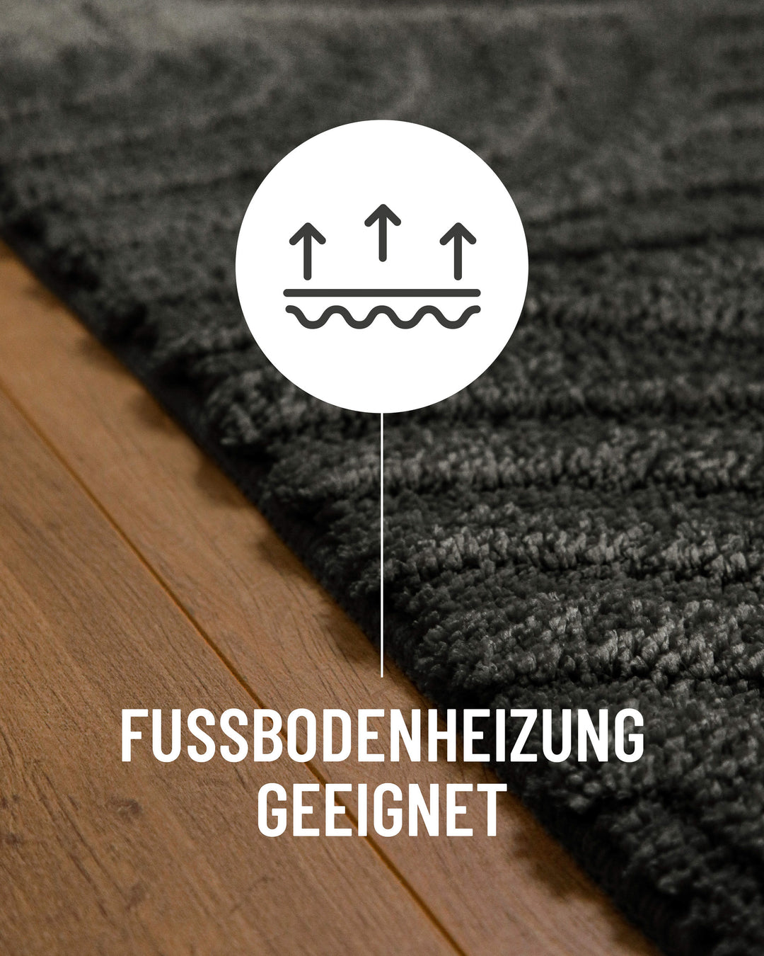 Badteppich Fiete Anthrazit Grau Detail auf Holzfußboden mit Symbol für Fußbodenheizung, Nahaufnahme von Flor und Teppichkante