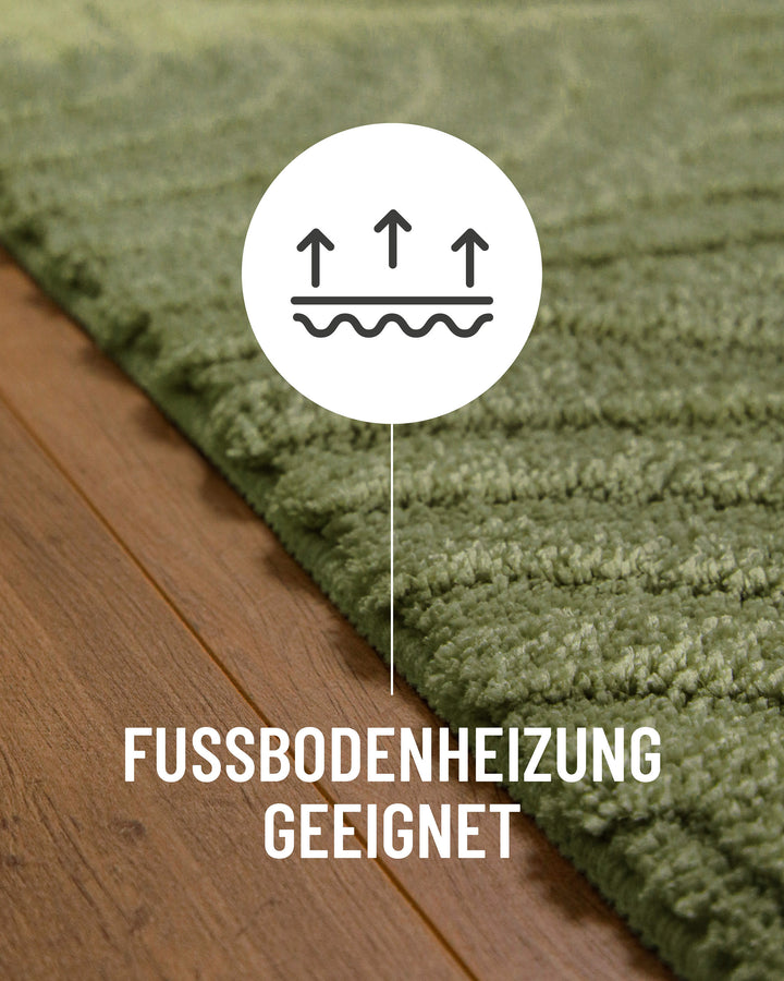 Badteppich Fiete Reseda Grün Detail auf Holzfußboden mit Symbol für Fußbodenheizung, Nahaufnahme von Flor und Teppichkante