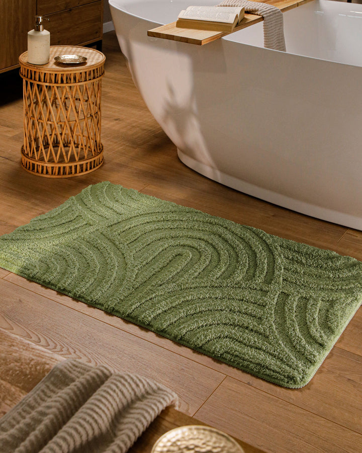 Badteppich Fiete Reseda Grün rechteckig im Badezimmer vor Badewanne auf Holzboden liegend, Strukturmuster im Flor sichtbar