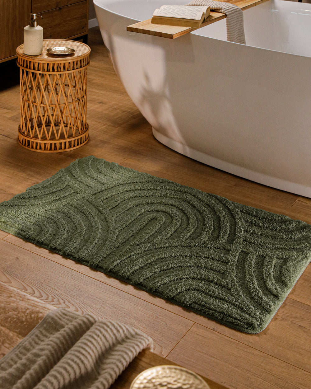 Badteppich Fiete Kiefer Grün rechteckig im Badezimmer vor Badewanne auf Holzboden liegend, Strukturmuster im Flor sichtbar