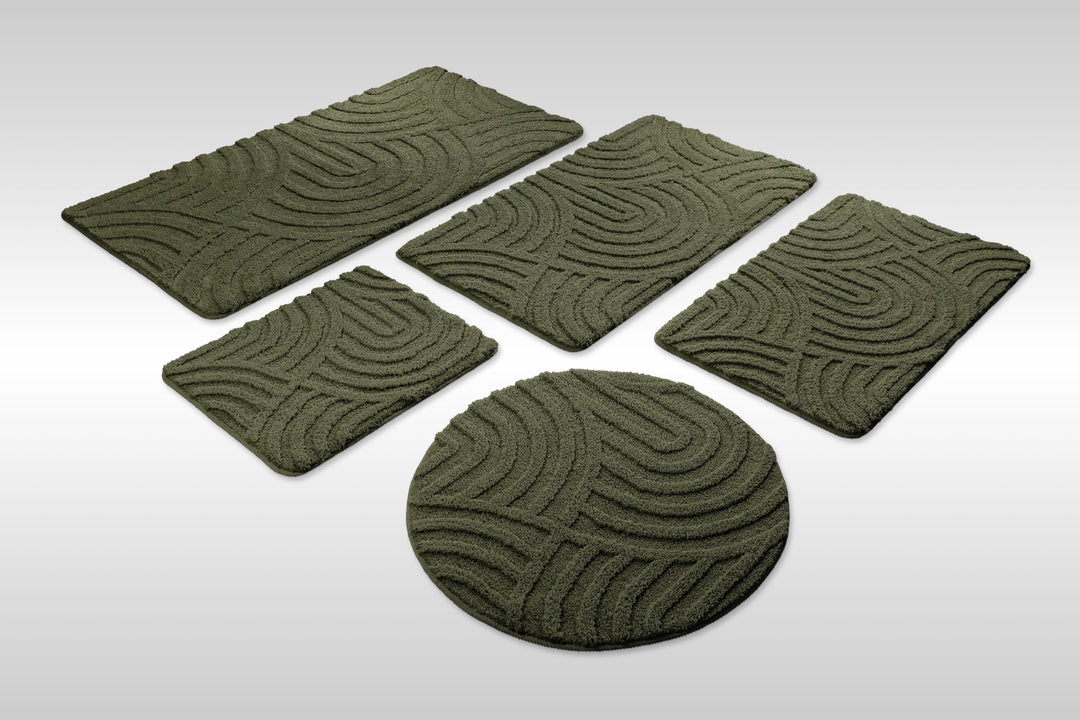 Badteppich Fiete Kiefer Grün Set aus rechteckigen und runden Badmatten, mehrere Größen auf hellem Hintergrund angeordnet