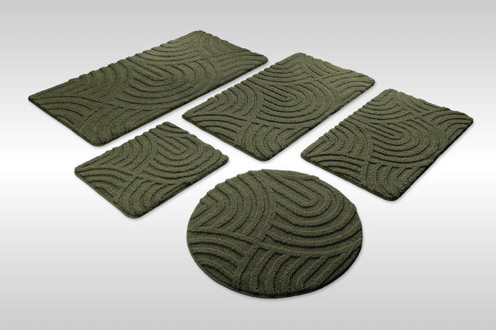 Badteppich Fiete Kiefer Grün Set aus rechteckigen und runden Badmatten, mehrere Größen auf hellem Hintergrund angeordnet