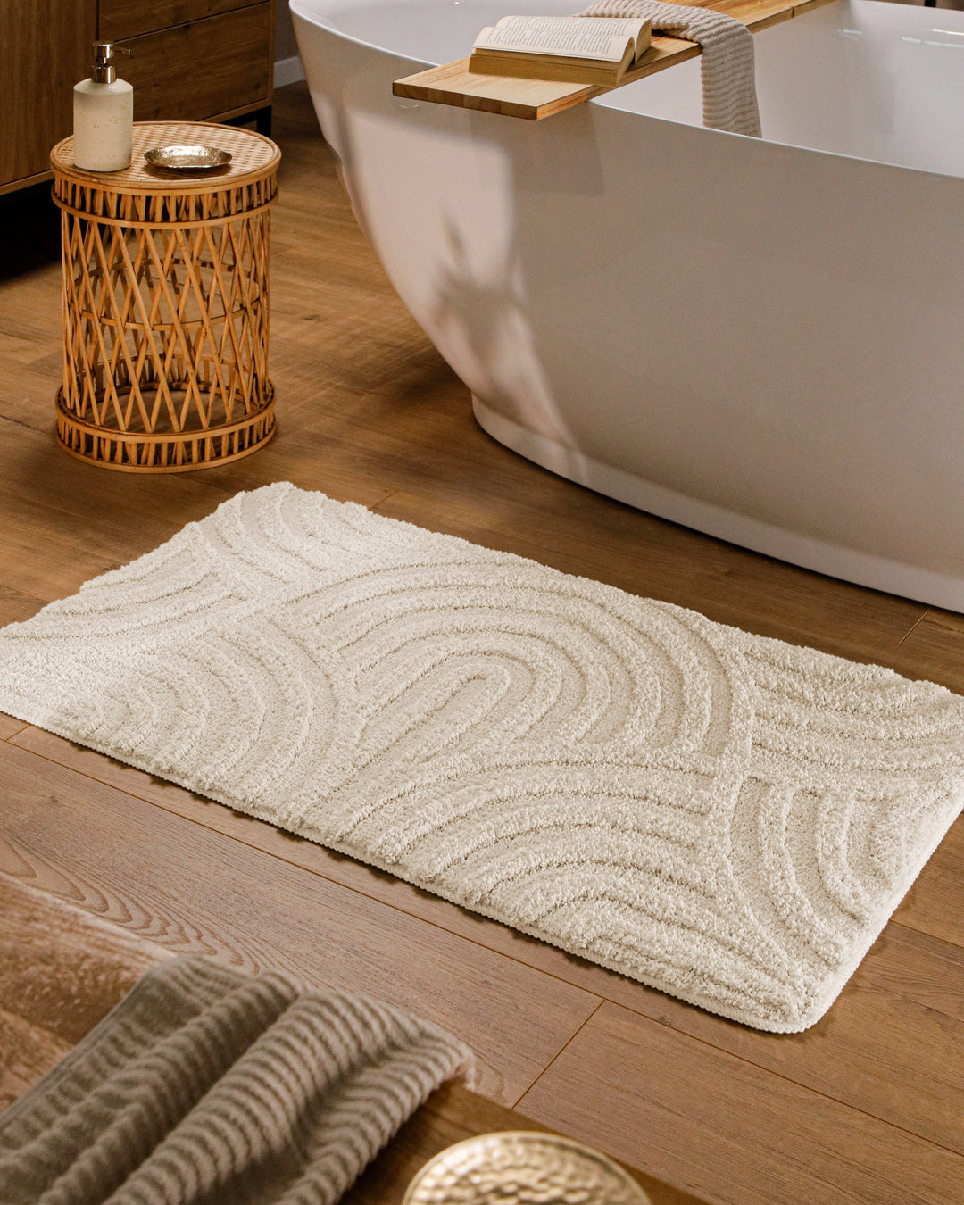 Badteppich Fiete Creme Weiß rechteckig im Badezimmer vor Badewanne auf Holzboden liegend, Strukturmuster im Flor sichtbar
