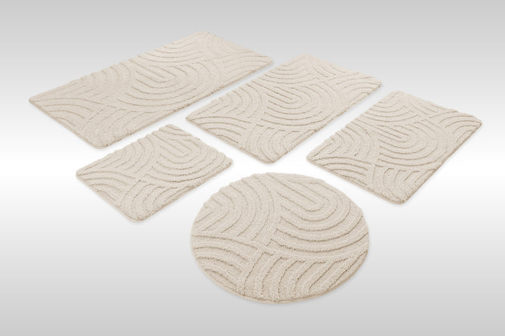 Badteppich Fiete Creme Weiß Set aus rechteckigen und runden Badmatten, mehrere Größen auf hellem Hintergrund angeordnet