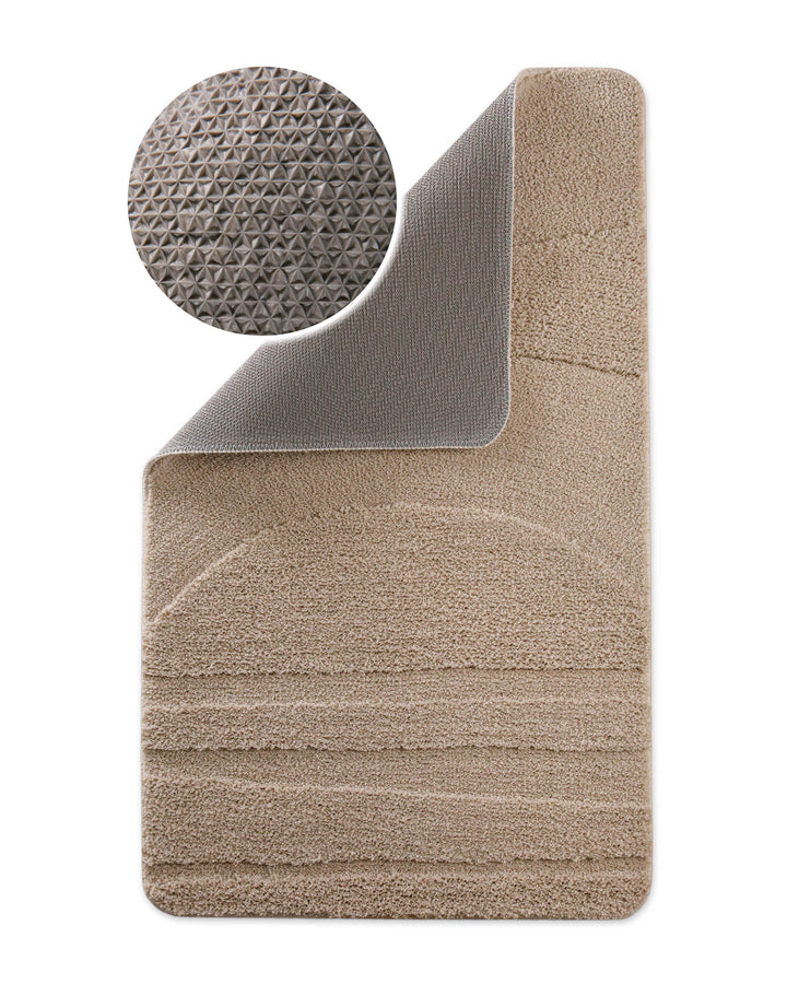 Badteppich Marc Sand Beige Ecke hochgeklappt, runde Probe zeigt Sand Beigee Rückseite mit rutschhemmender Beschichtung