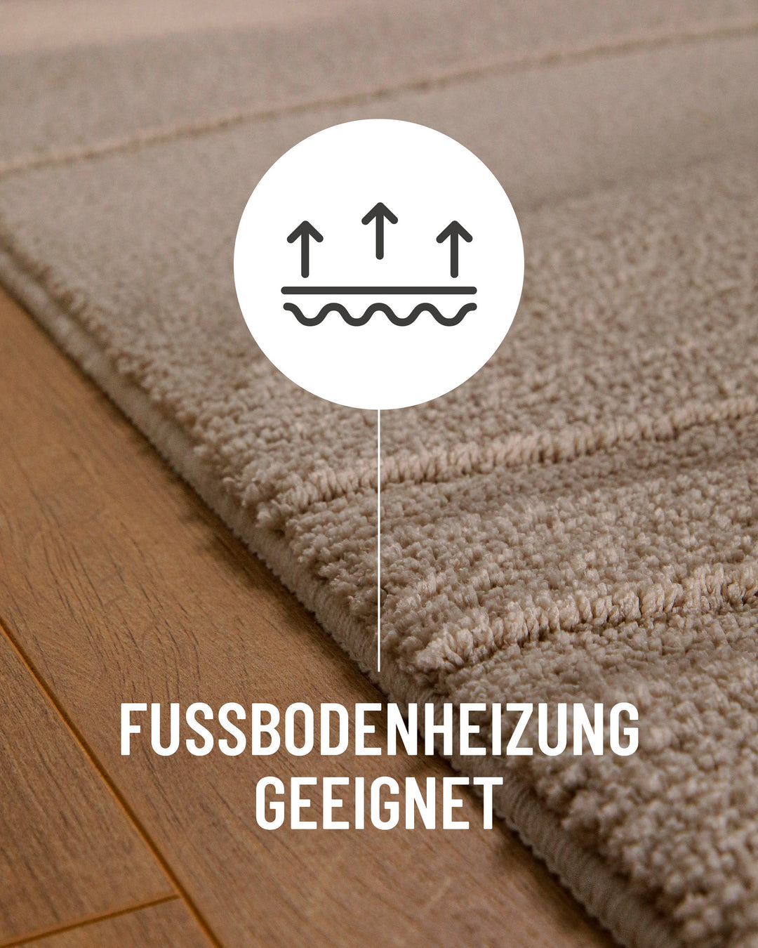 Badteppich Marc Sand Beige Detail auf Holzfußboden mit Symbol für Fußbodenheizung, Nahaufnahme von Flor und Teppichkante