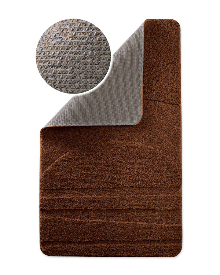 Badteppich Marc Braun Ecke hochgeklappt, runde Probe zeigt Braune Rückseite mit rutschhemmender Beschichtung