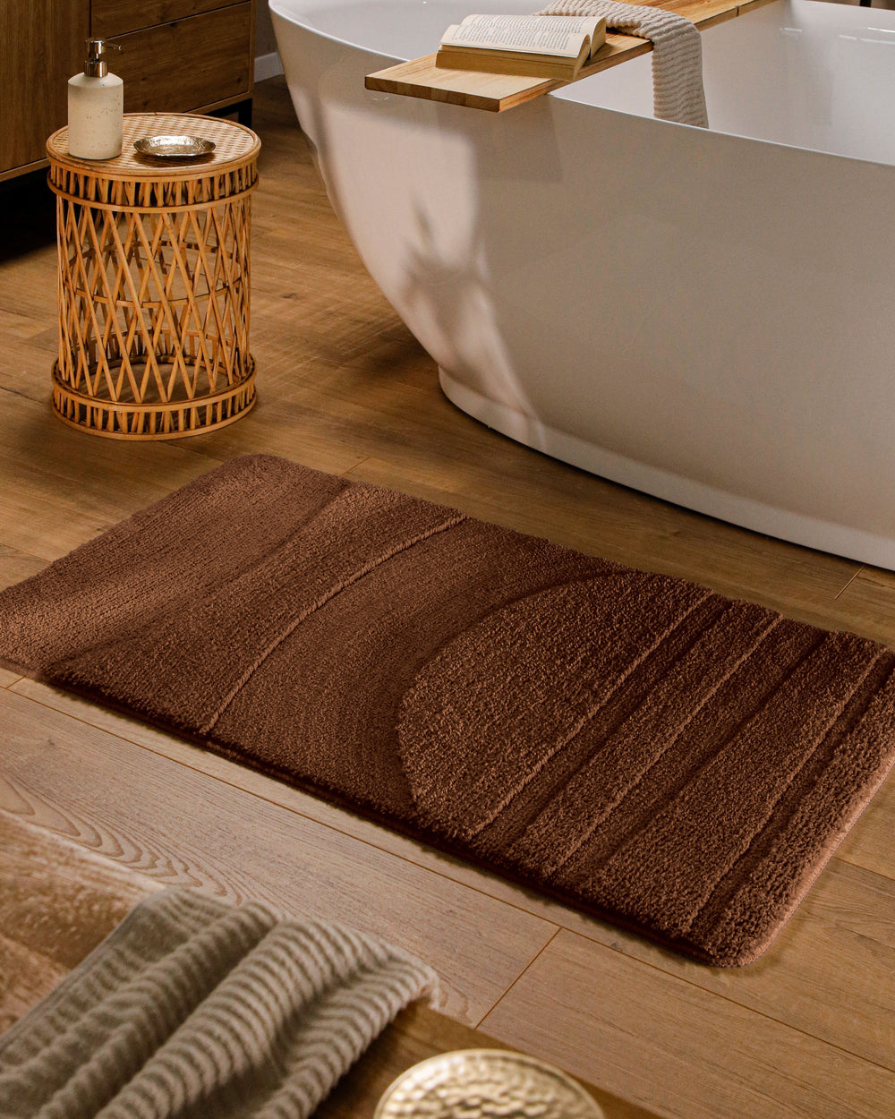 Badteppich Marc Braun rechteckig im Badezimmer vor Badewanne auf Holzboden liegend, Strukturmuster im Flor sichtbar