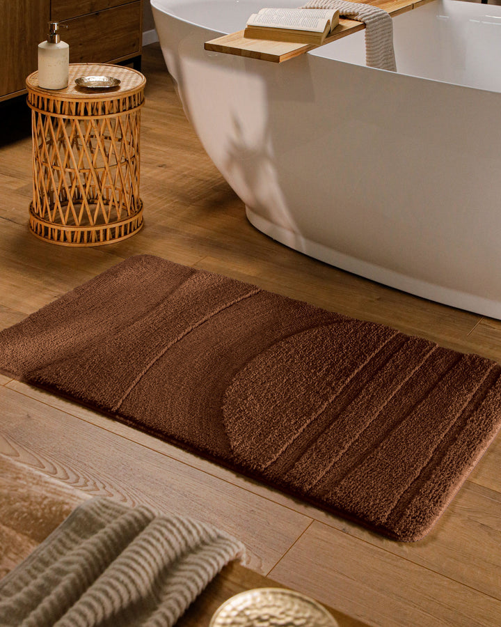 Badteppich Marc Braun rechteckig im Badezimmer vor Badewanne auf Holzboden liegend, Strukturmuster im Flor sichtbar