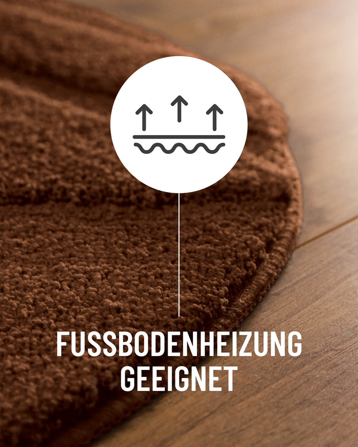 Badteppich Marc Braun Detail der Teppichkante auf Holzboden, Symbol weist auf Eignung für Fußbodenheizung hin