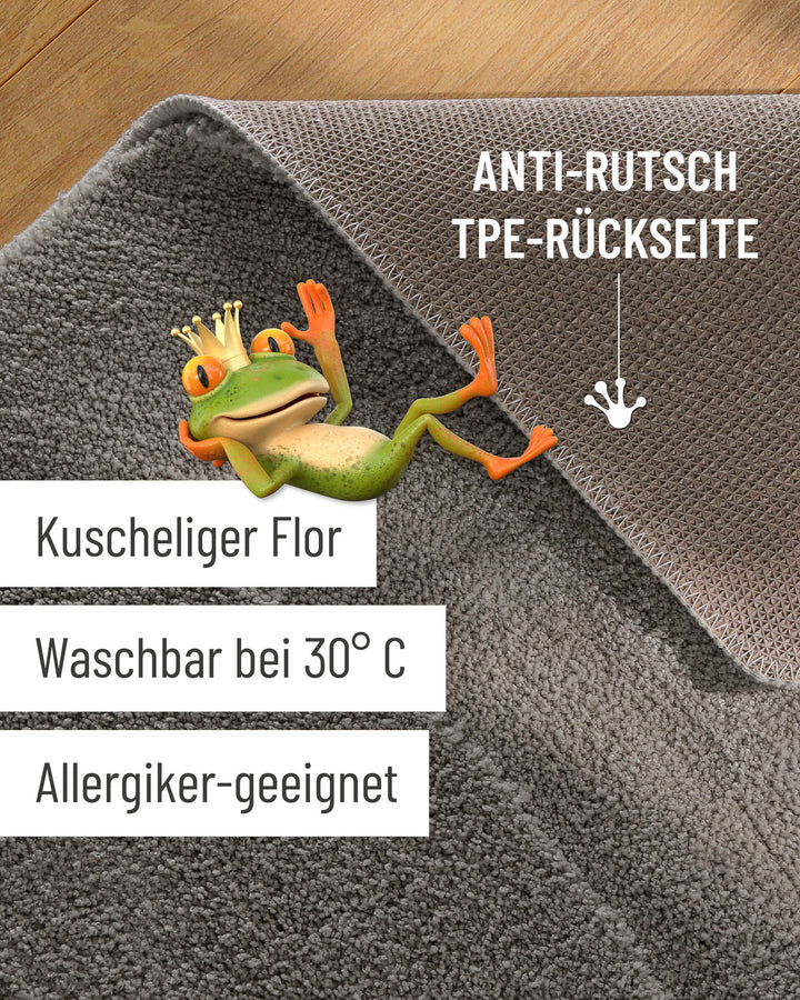 Badteppich Marc Basalt Grau Detailaufnahme Flor auf Holzfußboden, eingeblendete Hinweise zu rutschhemmender Rückseite und Waschbarkeit