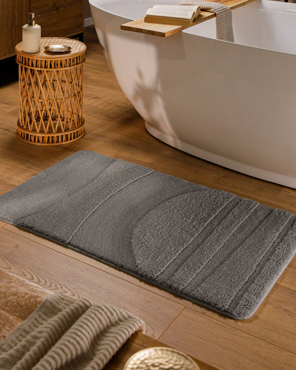 Badteppich Marc Basalt Grau rechteckig im Badezimmer vor Badewanne auf Holzboden liegend, Strukturmuster im Flor sichtbar