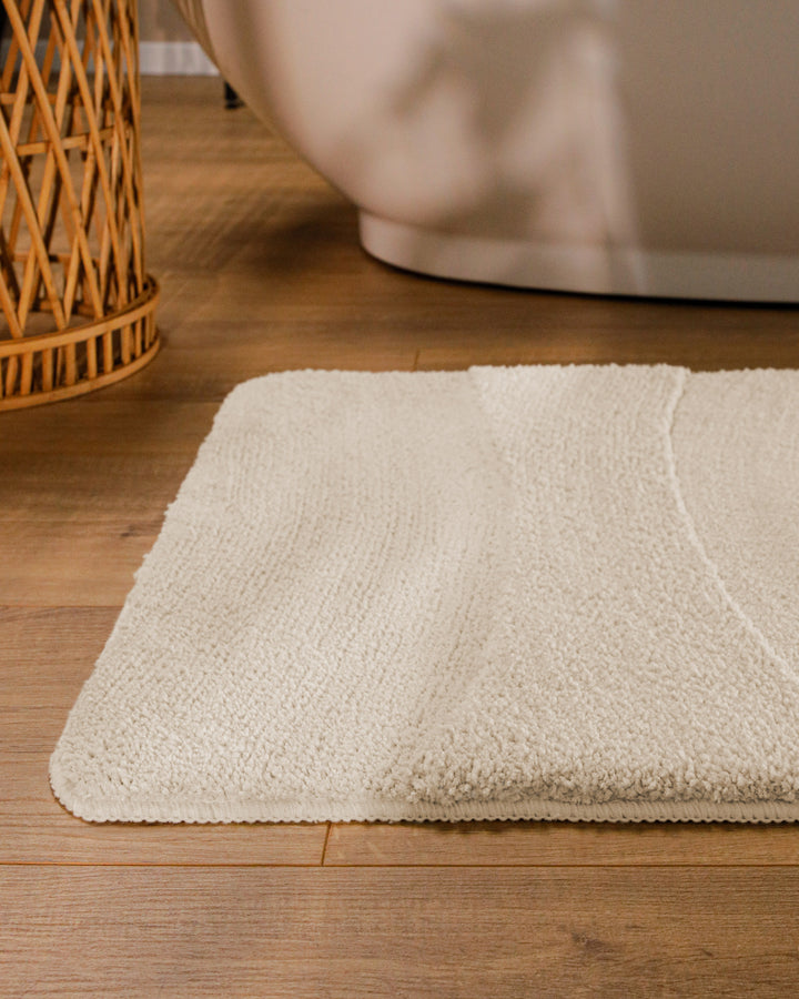 Badteppich Marc Creme Weiß runde Matte im Badezimmer vor Badewanne, Strukturmuster im Flor auf Holzboden sichtbar