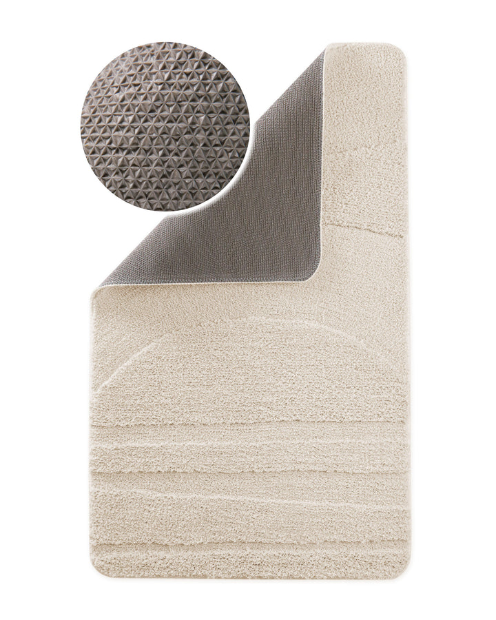 Badteppich Marc Creme Weiß Ecke hochgeklappt, runde Probe zeigt Creme Weiße Rückseite mit rutschhemmender Beschichtung