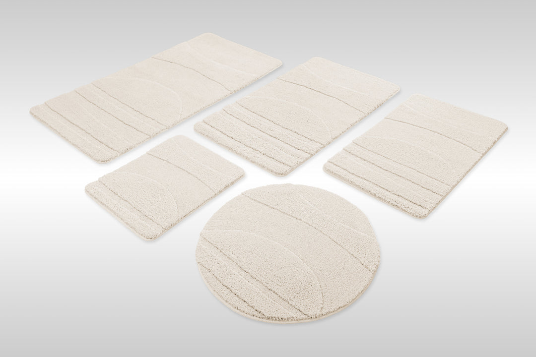 Badteppich Marc Creme Weiß Set aus rechteckigen und runden Badmatten, mehrere Größen auf hellem Hintergrund angeordnet