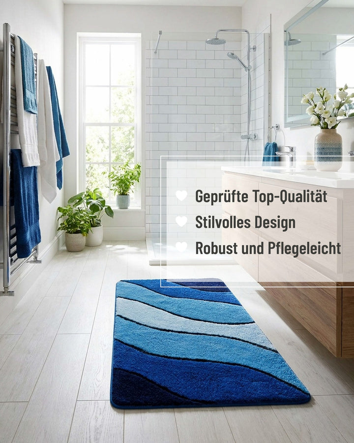 Blauer Badteppich Monte Cavo vor einer freistehenden Badewanne mit Badezimmereinrichtung, mit eingeblendeten Qualitätsversprechen: geprüfte Top-Qualität, stilvolles Design, robust und pflegeleicht