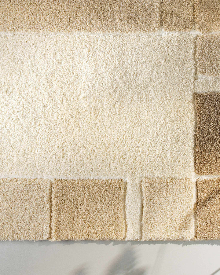 Draufsicht auf die untere Ecke des Badteppichs Villa Elba – cremefarbenes Mittelfeld mit angrenzender Beige-Blockbordüre und sichtbarem Übergang zur Teppichkante