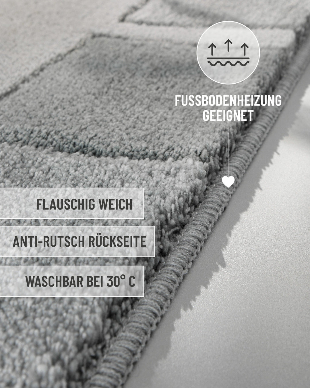 Seitliche Nahaufnahme der Teppichkante des Badteppichs Villa Elba in Grau mit eingeblendeten Produktvorteilen: flauschig weich, Anti-Rutsch-Rückseite, waschbar bei 30°C, Fußbodenheizung geeignet