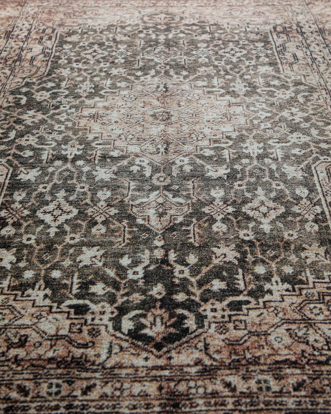 Makroaufnahme der weichen Oberfläche und des detailreichen Ethno-Musters des beige-grauen Badteppichs Ralph.