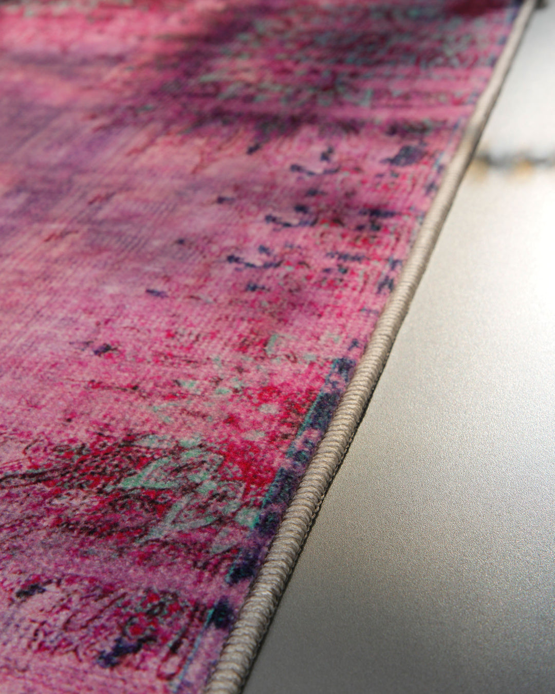 Nahaufnahme der sauber eingefassten Kante des Vintage-Badteppichs Healing in Violett-Multi.