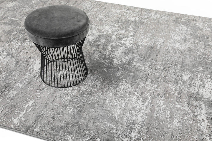 Esprit Feel Vintage 2.0 Teppich Grau Silber im Wohnraum mit Hocker, zeigt Nutzung und Farbwirkung im Raum