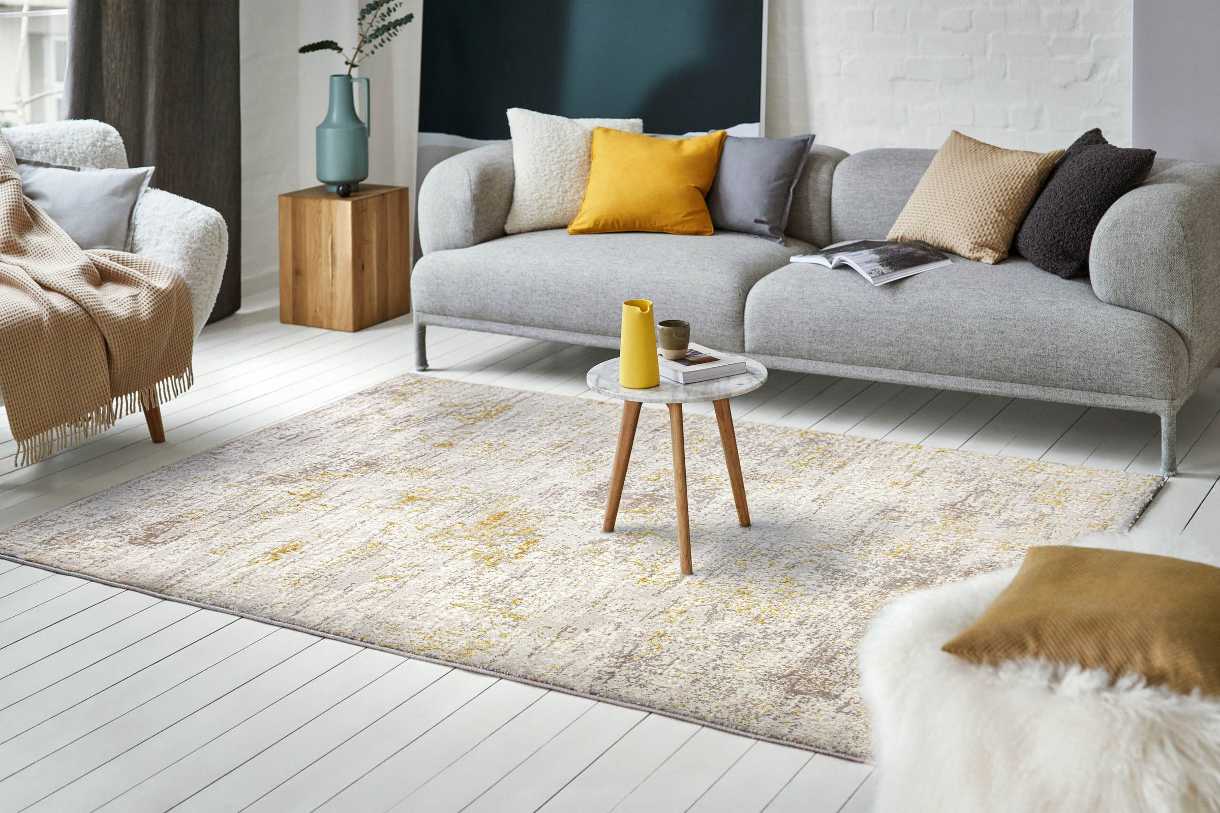 Esprit Feel Vintage 2.0 Teppich Creme Gold Interieuraufnahme mit grauem Sofa dekorativen Kissen