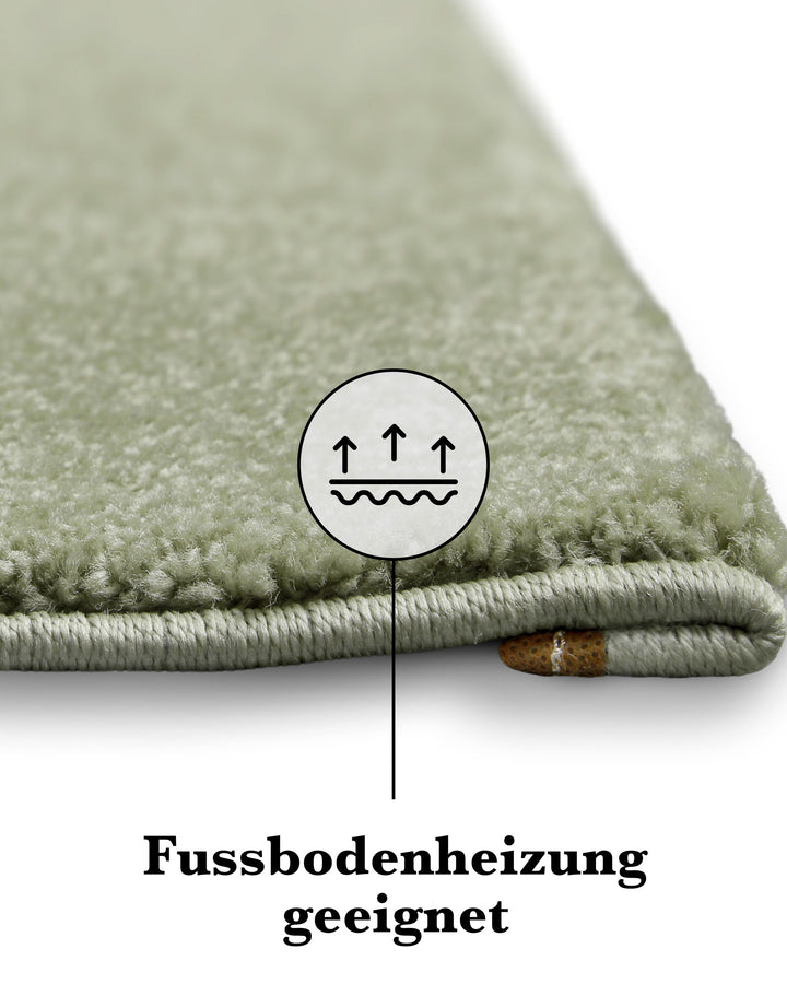 Kurzflor Teppich Freja Licht Grün Detailaufnahme der Kante mit Symbol für Fußbodenheizung geeignet