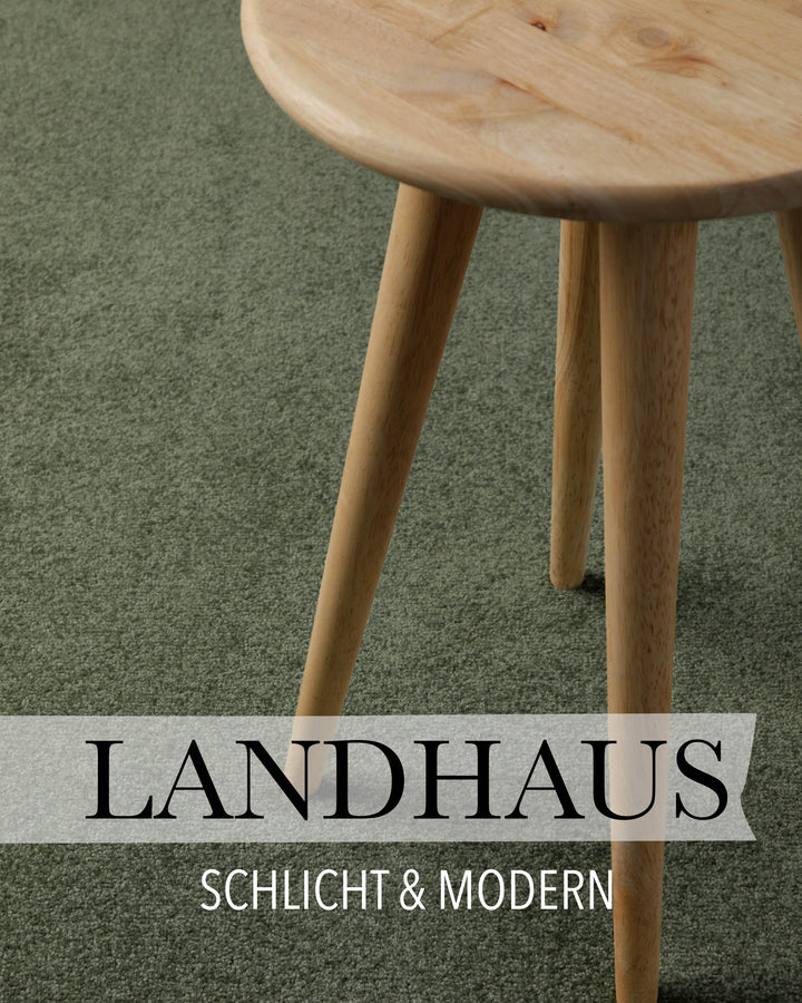 Kurzflor Teppich Freja Laub Grün im Wohnraum mit Schriftzug Landhaus, zeigt gemütliche Raumwirkung